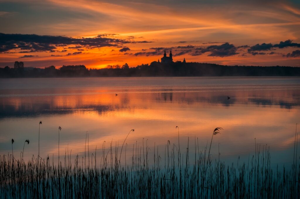 serene lake sunset with silhouette of church